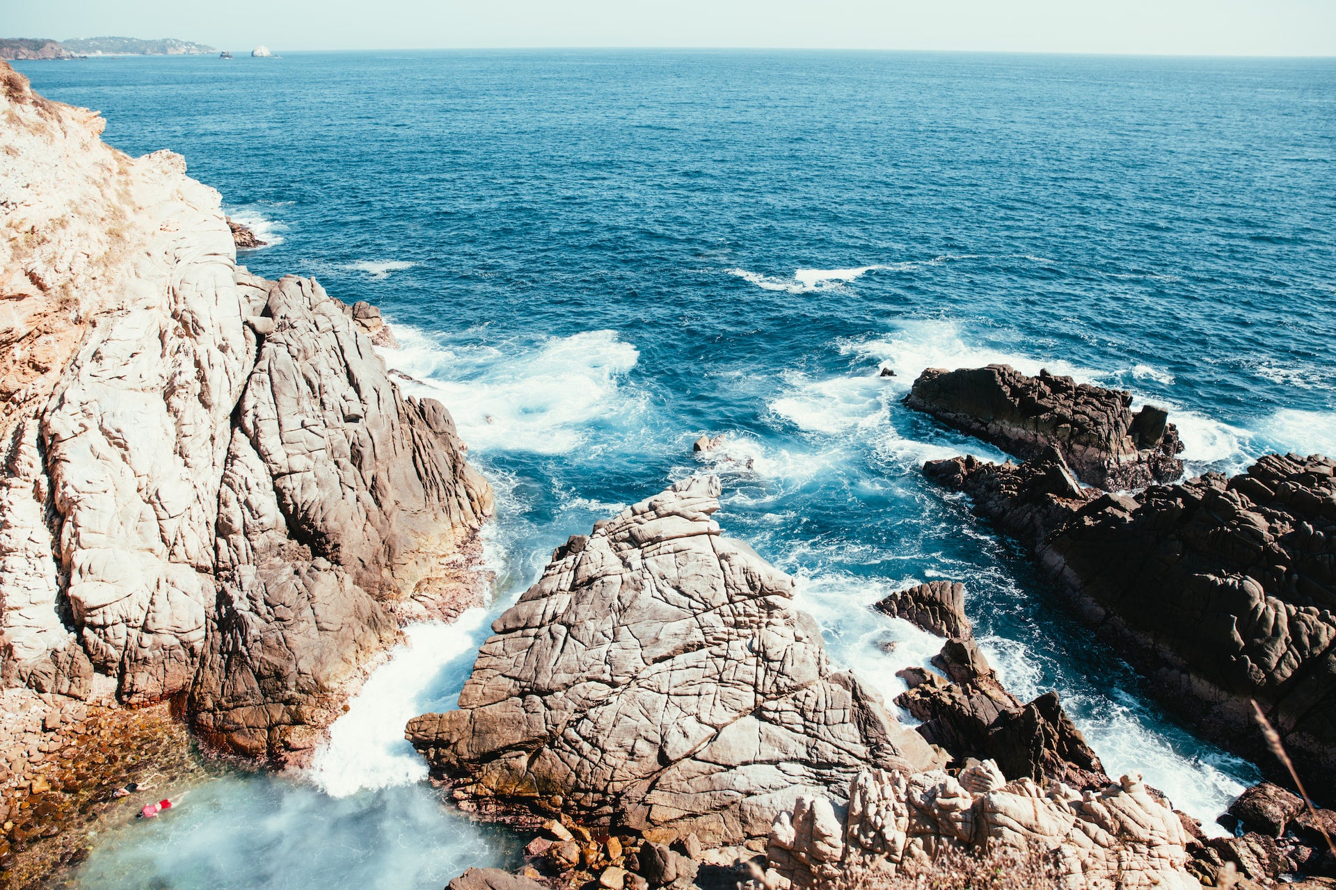 Rocky Greek coastline with ocean waves crashing against the rocks